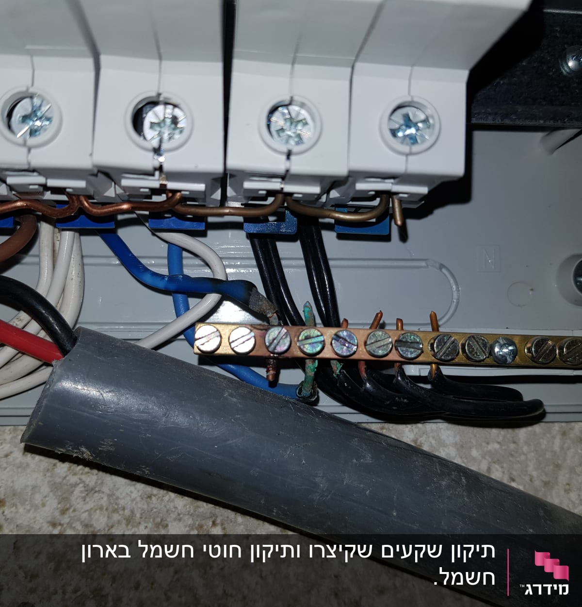 חוטי חשמל צבעוניים מחוברים ללוח חשמל עם ברגים